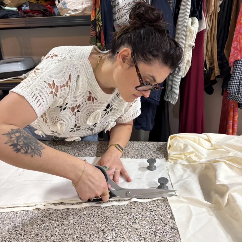 Charlène Le Scodan découpant du textile pour la confection vestimentaire.